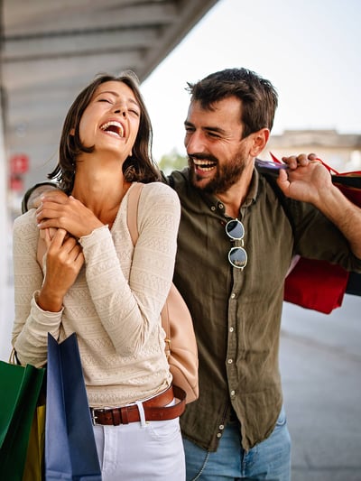 Couple smiling while holding shopping bags
