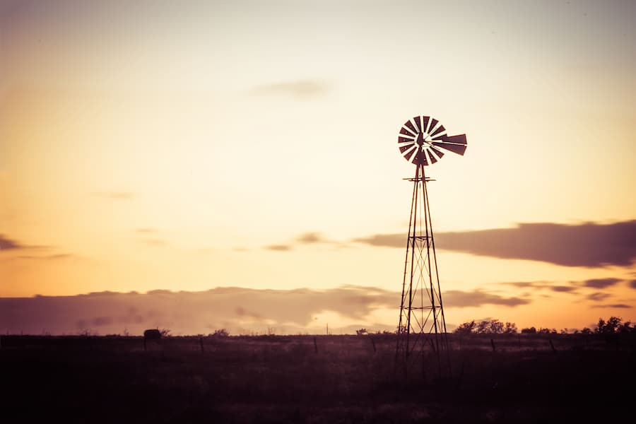 Sunset over a rural field and windmill in Piedmont, Oklahoma.