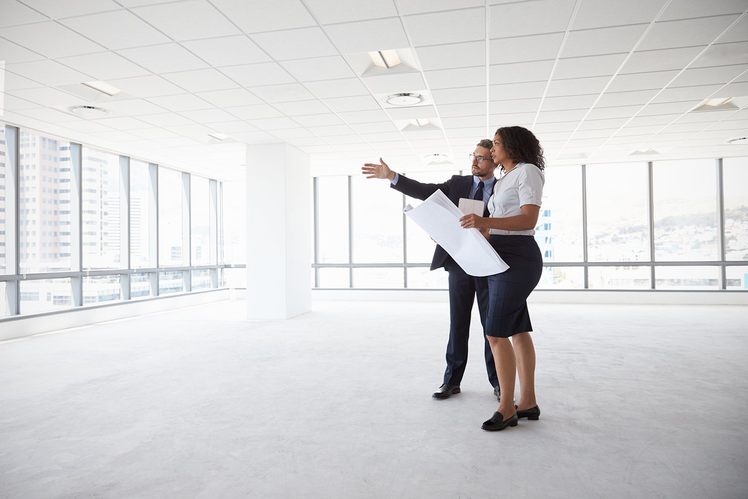 A woman views an office building after securing a commercial real estate loan.