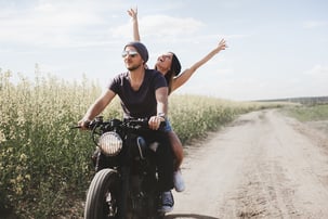 A couple enjoys a ride in an Oklahoma field on a motorcycle  bought with a motorcycle loan.