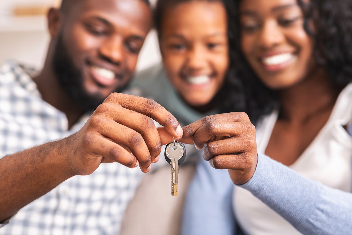 A happy family holds the keys to their new home bought with a fixed-rate mortgage.