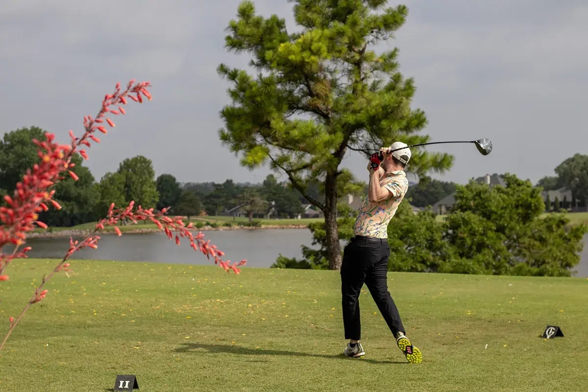 Participant taking a swing on the green during the 20th Annual WEOKIE Foundation Golf Classic