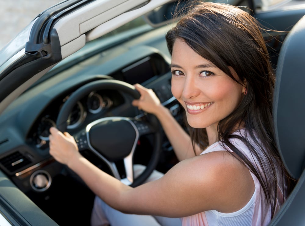 Happy casual woman driving a convertible car