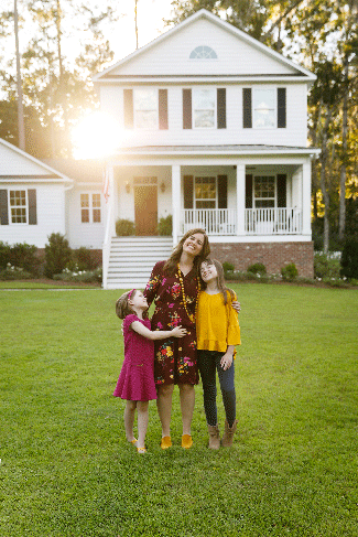 Mom-and-Two-Daughters-Laughing-and-Hugging-Outside-their-New-Farmhouse-Home