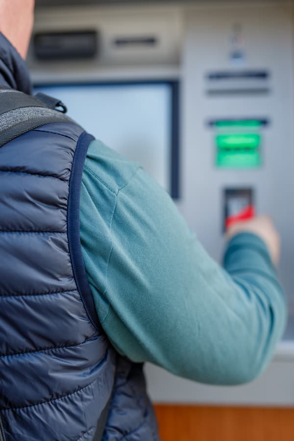 A man using an ATM at a Co-op Shared Branch to withdraw money from his account.
