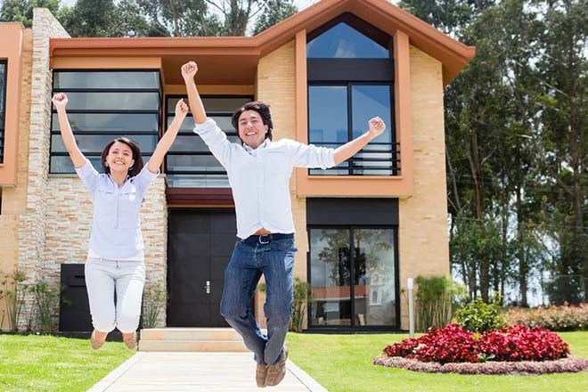 Excited couple jumping after buying a house