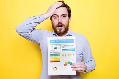 Worried-man-holding-poor-score-credit-rating-isolated