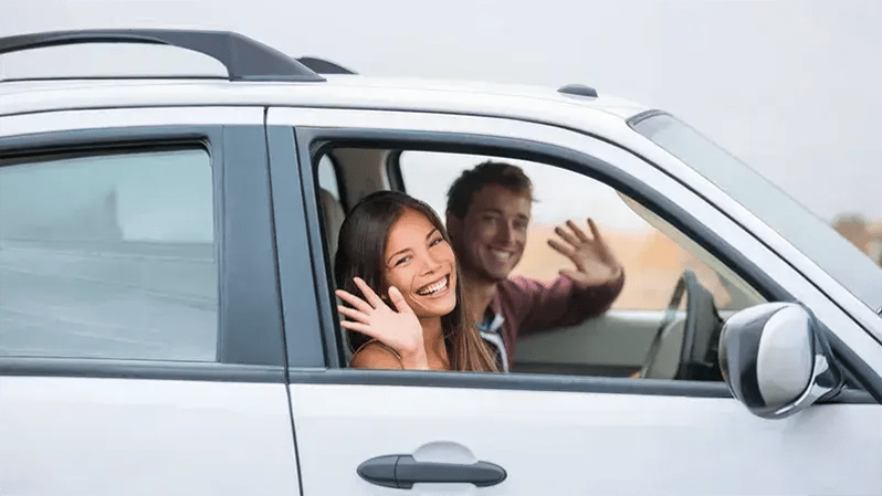 Smiling couple inside a car financed with a WEOKIE auto loan