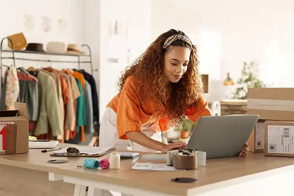 Small business owner working on a laptop while managing business finances