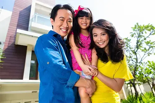 Happy family in front of new home with zero down No PMI home loan
