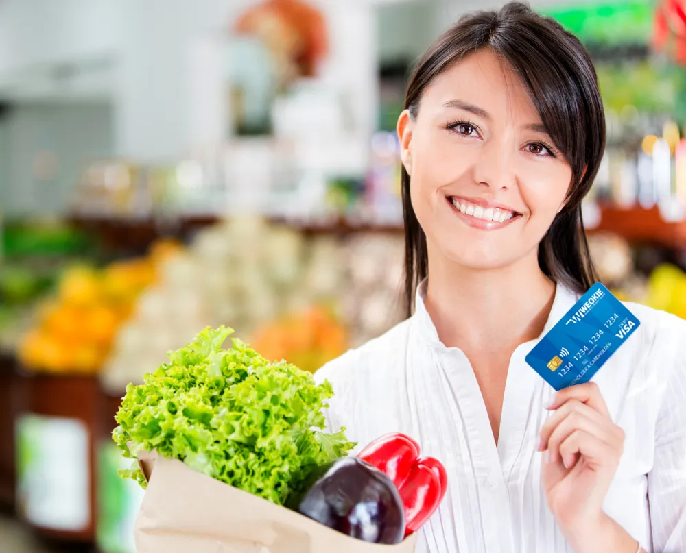 Shopping woman with a credit card looking happy