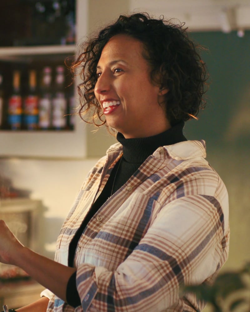Woman smiling and interacting with someone in a café or shop setting