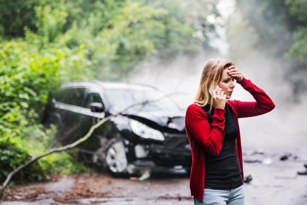 a-young-woman-with-smartphone-by-the-damaged-car-a-LF7G486-min-1024x683