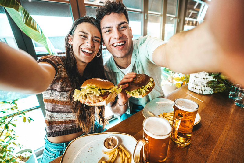A young couple taking a selfie at a restaurant.