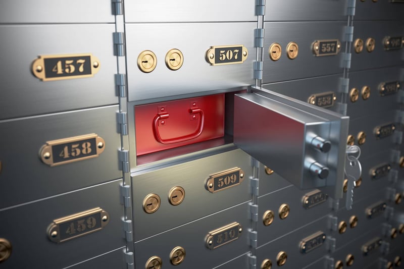 Open safe deposit box in a credit union vault with numbered metal drawers
