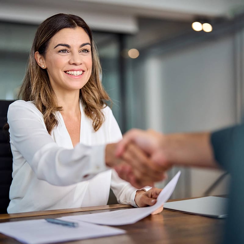 Professional woman smiling and shaking hands at the WEOKIE Federal Credit Union Edmond location